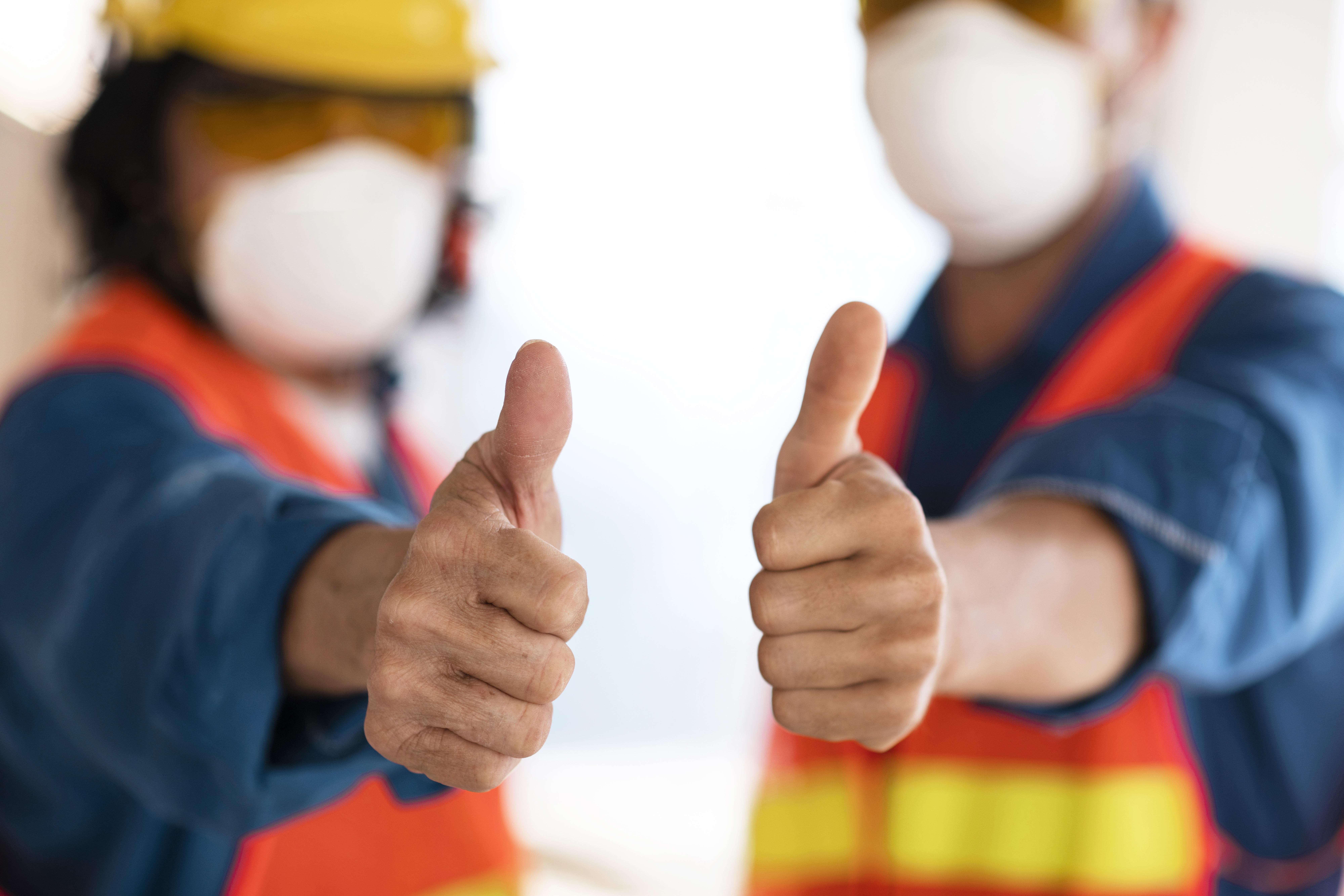 colleagues with safety equipment showing ok sign1